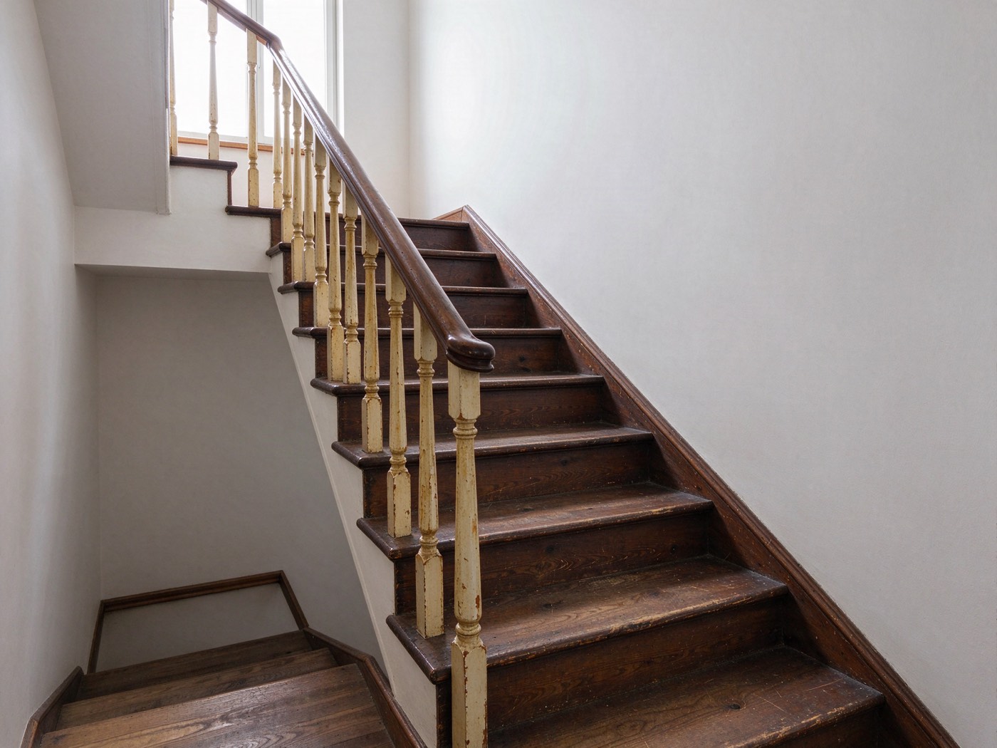 Die Treppe vorher: dunkler, abgenutzter Lack, zerkratzte Stufen