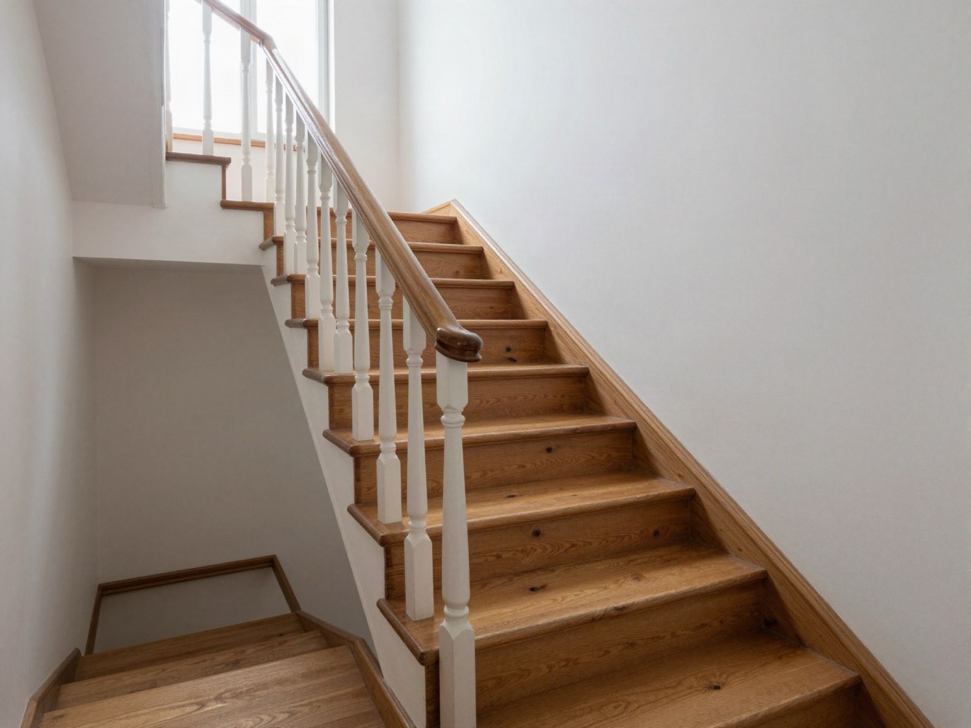 Die Treppe nachher: helle, geölte Kiefernstufen, weiße Geländerstäbe
